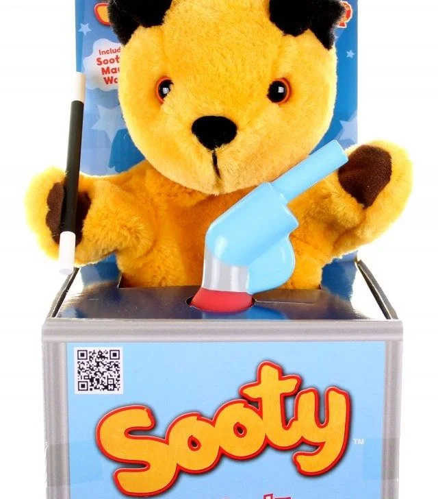 This image shows a limited edition water pistol, a Sooty TM pop-up puppet show, and a Sooty TM mascot costume being included in a package.