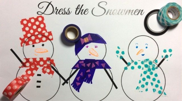 A child is proudly displaying their handmade craft of two snowmen dressed in colorful scarves and hats.