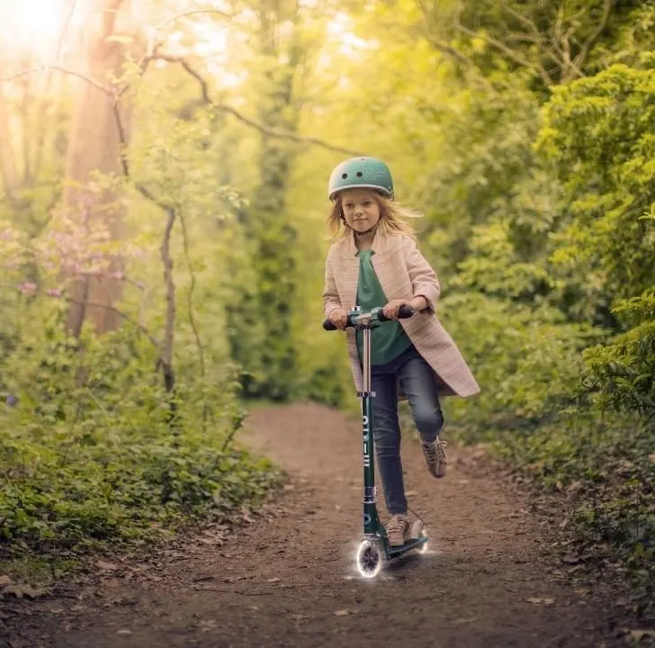 A young person is running along a path in a forest, hiking through nature and admiring the trees and plants along the trail.