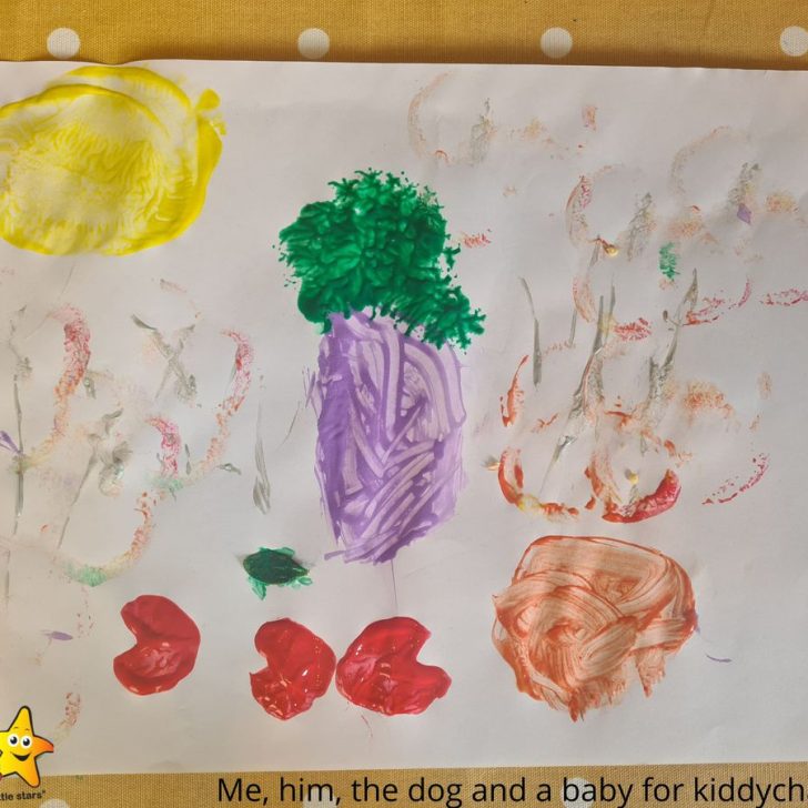 A child is actively painting a colorful illustration of a family of four, including a dog, with the text 