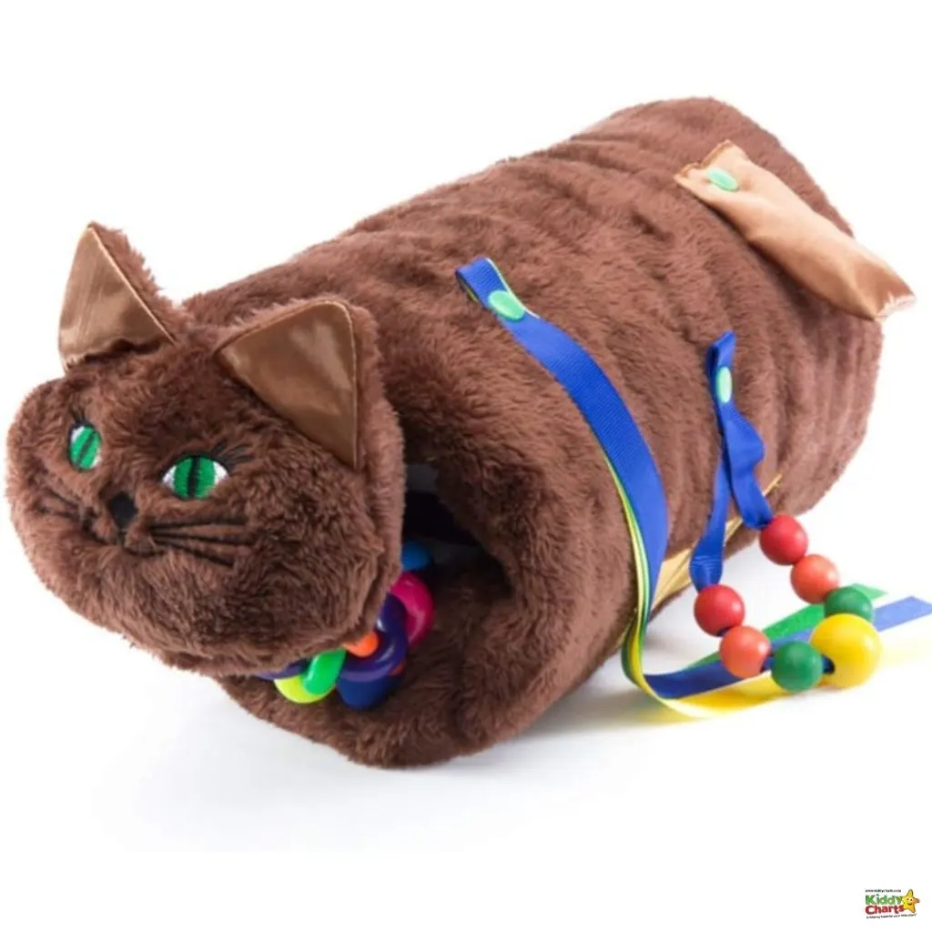 The image shows a plush tunnel toy designed to resemble a cat, featuring green eyes, and is adorned with colorful ribbons and beads.