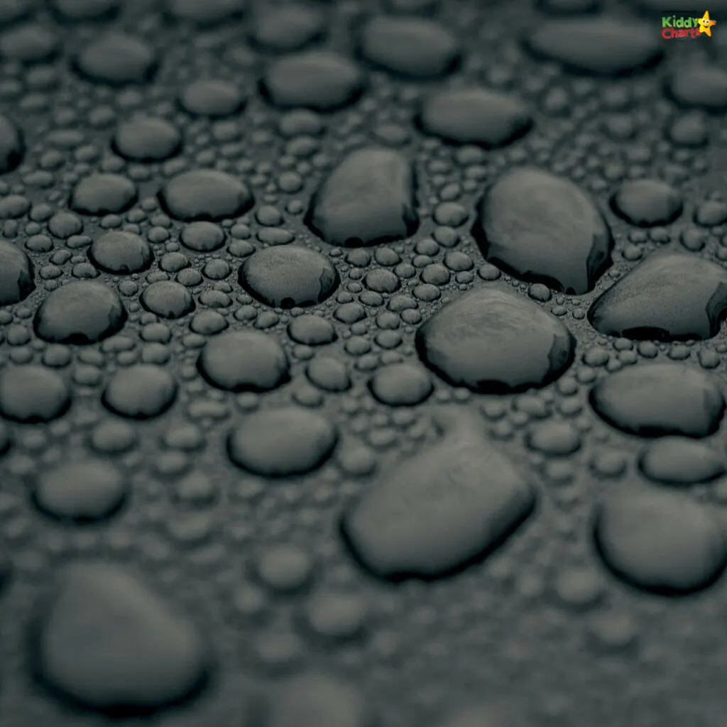 This image shows numerous water droplets on a surface, captured in a monochrome tone, varying in size and displaying a high level of detail.