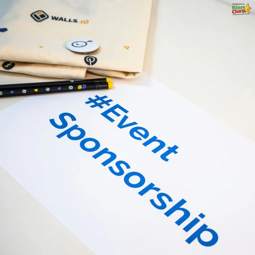 The image shows a piece of paper with "#EventSponsorship" printed in blue, alongside a white tote bag with logos, a badge, and multicolored pens.