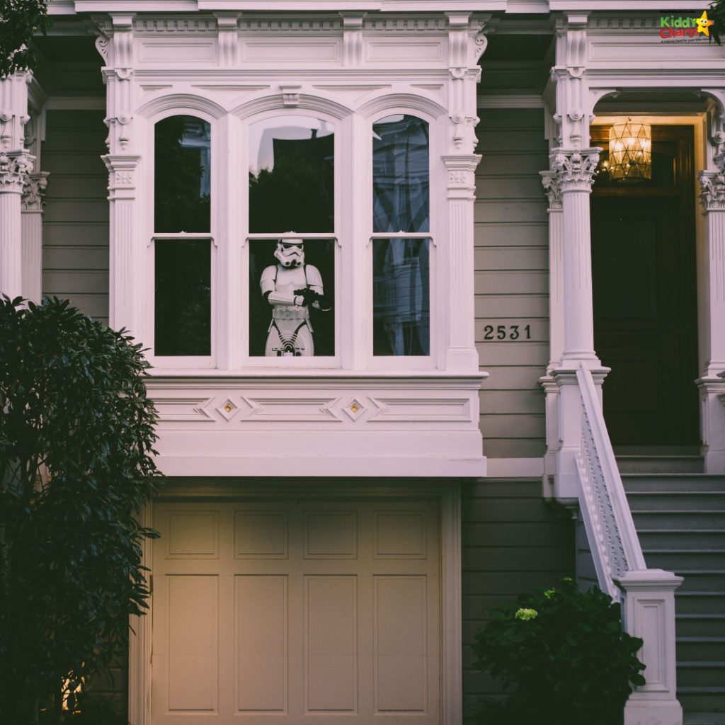 An elegant Victorian-style house with ornate window trims, featuring a Stormtrooper figure standing inside, against twilight ambiance. Address "2531" is prominently displayed.